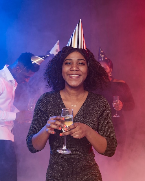 Kostenloses Foto vorderansicht junge frau, die ein glas champagner hält