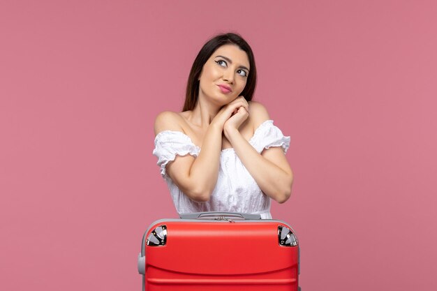 Vorderansicht junge Frau, die für Urlaub mit ihrer Tasche auf dem rosa Hintergrund im Ausland Seereise Reise Reise Reise vorbereitet