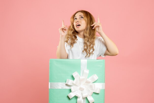 Vorderansicht junge Frau, die innerhalb der blauen Geschenkbox steht