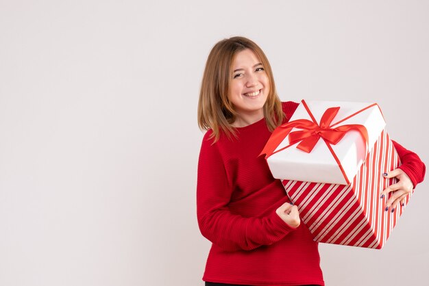 Vorderansicht junge Frau, die mit Geschenkbox in ihren Händen steht