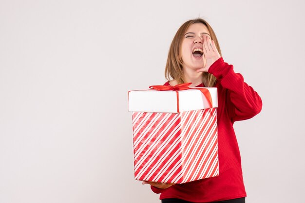 Vorderansicht junge Frau, die mit Geschenkbox in ihren Händen steht