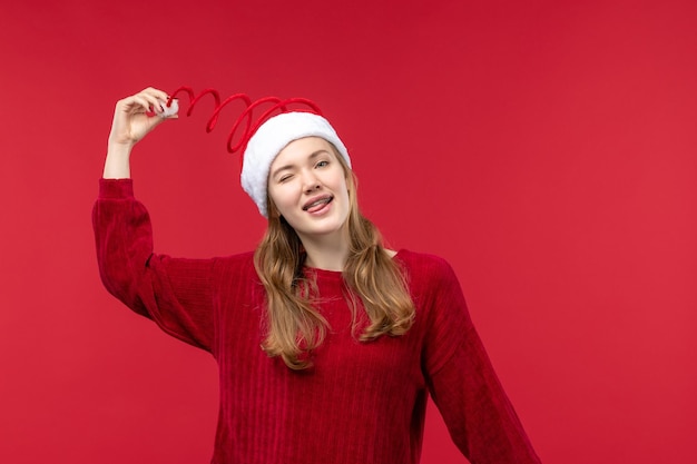 Vorderansicht junge Frau, die mit ihrer Weihnachtsmütze spielt, Frauenferien rot