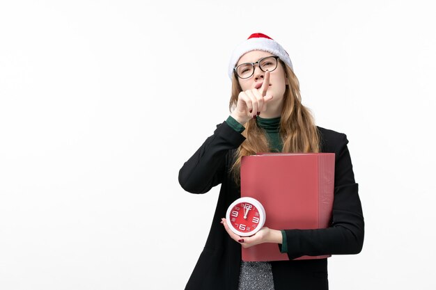 Vorderansicht junge Frau, die Uhr und Dateien auf weißer Wand College-Bücher Lektion hält