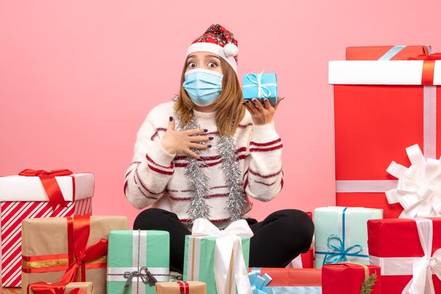 Vorderansicht junge Frau, die um Geschenke sitzt