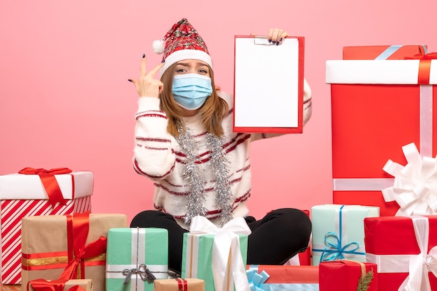 Kostenloses Foto vorderansicht junge frau, die um geschenke sitzt