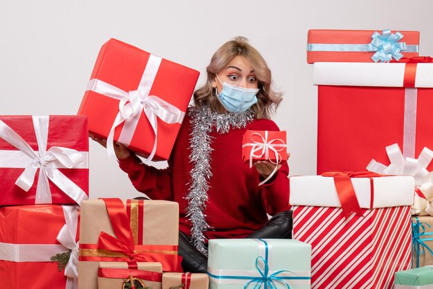 Vorderansicht junge Frau, die um verschiedene Geschenke sitzt