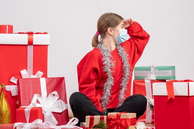 Vorderansicht junge Frau, die um Weihnachtsgeschenke in der Maske sitzt