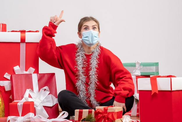 Vorderansicht junge Frau, die um Weihnachtsgeschenke in der Maske sitzt