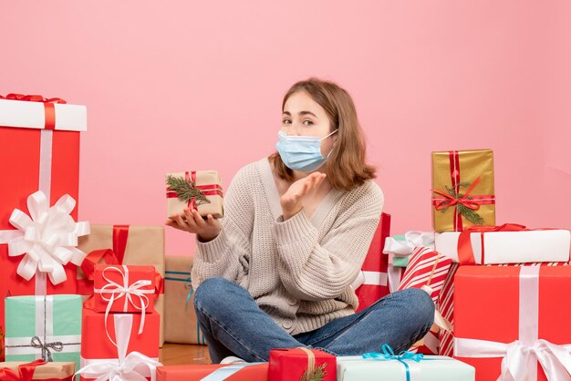 Vorderansicht junge Frau, die um Weihnachtsgeschenke in der Maske sitzt