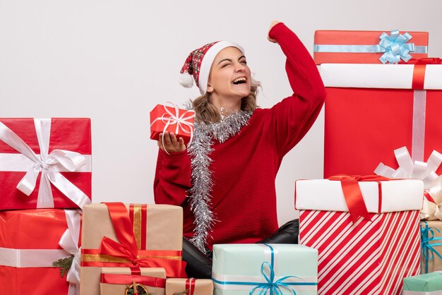 Vorderansicht junge Frau, die um Weihnachtsgeschenke sitzt