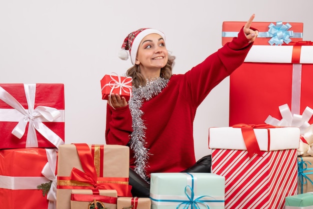 Vorderansicht junge Frau, die um Weihnachtsgeschenke sitzt