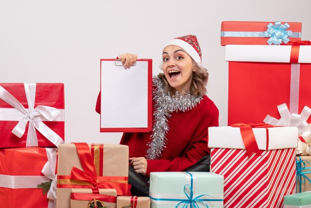 Vorderansicht junge Frau, die um Weihnachtsgeschenke sitzt