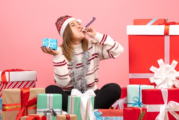 Vorderansicht junge Frau, die um Weihnachtsgeschenke sitzt