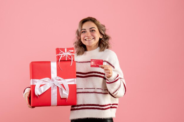 Vorderansicht junge Frau, die Weihnachtsgeschenke und Bankkarte hält