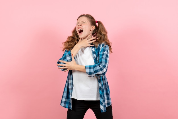 Vorderansicht junge Frau im karierten Hemd, das auf rosa Schreibtischfrauenkindjugendfarbemotionsmodell aufwirft