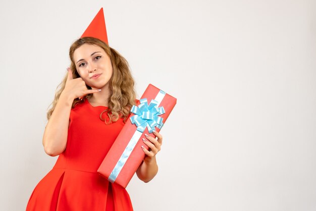Vorderansicht junge Frau im roten Kleid, das Weihnachten mit Geschenk feiert