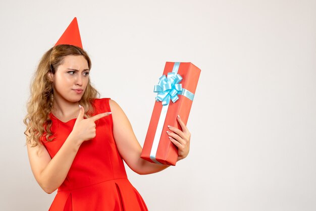 Vorderansicht junge Frau im roten Kleid, das Weihnachten mit Geschenk feiert