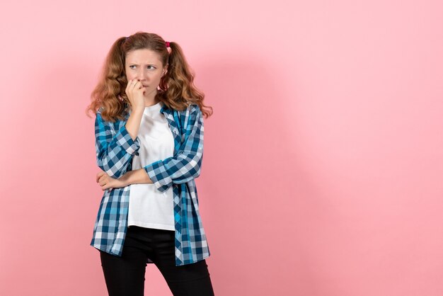 Vorderansicht junge Frau in blau kariertem Hemd posiert und denkt auf rosa Hintergrund Kind Mädchen Jugend Emotionen Modell Mode