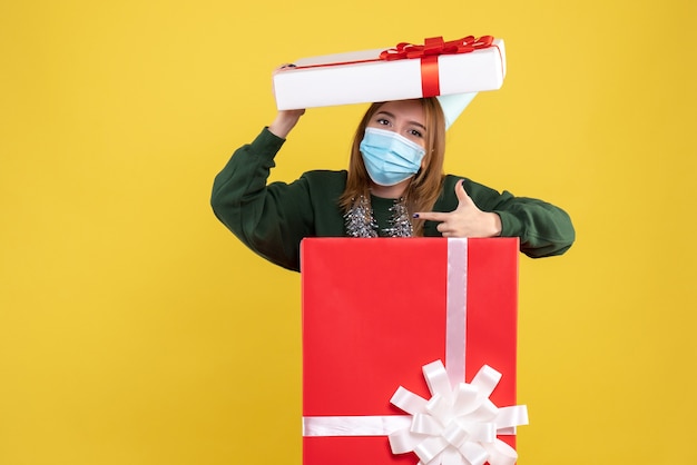 Kostenloses Foto vorderansicht junge frau in geschenkbox in steriler maske