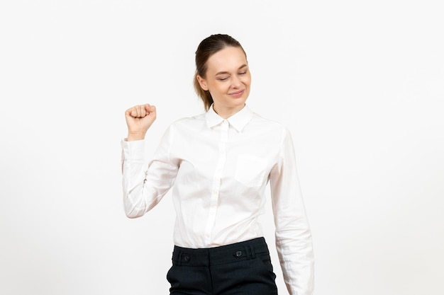 Vorderansicht junge Frau in weißer Bluse auf weißem Hintergrund Bürojob weibliche Emotion Gefühle Modell