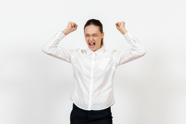 Vorderansicht junge Frau in weißer Bluse, die wütend Dateien auf weißem Hintergrund wirft weibliche Emotionen Gefühle Bürojob