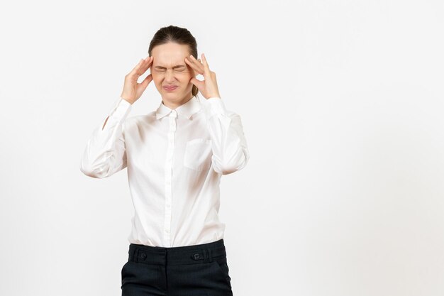 Vorderansicht junge Frau in weißer Bluse mit Kopfschmerzen auf weißem Hintergrund Job Büro weibliche Gefühl Modell Emotion