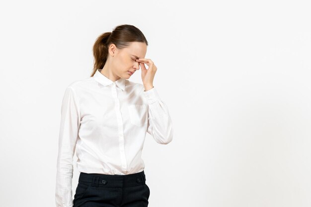 Vorderansicht junge Frau in weißer Bluse mit Kopfschmerzen auf weißem Hintergrund Job weibliches Gefühl Modell Emotion Büro