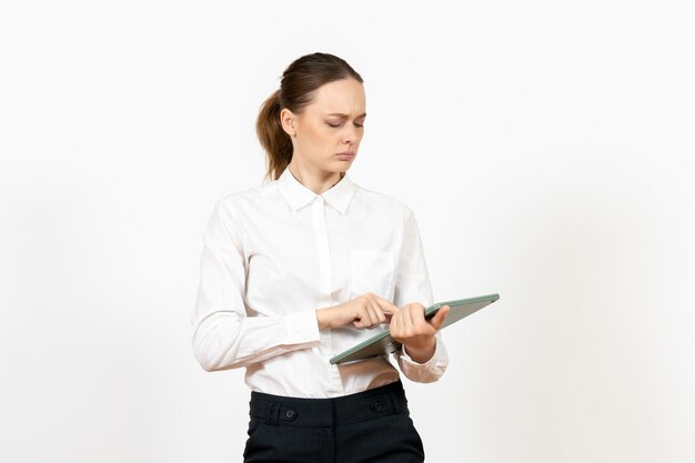 Vorderansicht junge Frau in weißer Bluse mit riesigen Taschenrechner auf weißem Schreibtisch Büro weibliche Emotion Gefühl Job emotion