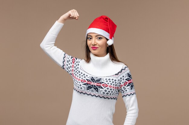 Vorderansicht junge Frau lächelnd und biegend auf braunem Hintergrund Emotion Weihnachten Neujahr