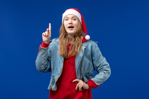 Vorderansicht junge Frau mit aufgeregtem Ausdruck auf dem blauen Hintergrund Neujahrsfeiertag Weihnachten