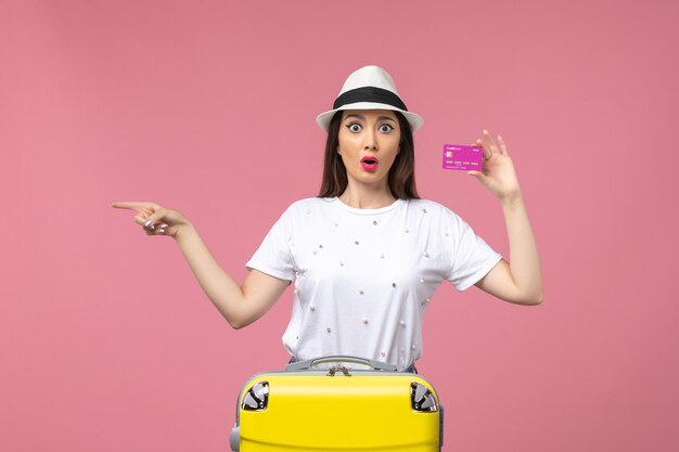 Vorderansicht junge Frau mit Bankkarte auf der rosa Wand Urlaub Geld Frau Reise