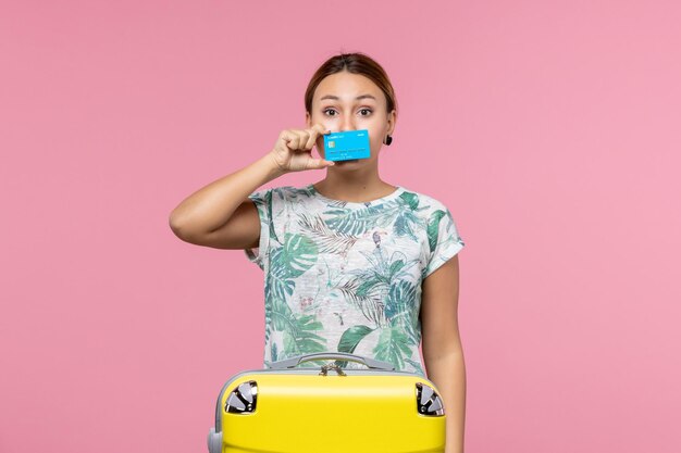 Vorderansicht junge Frau mit Bankkarte mit gelber Tasche auf der rosa Wand Flugzeug Urlaub Flug Reise Frau Rest