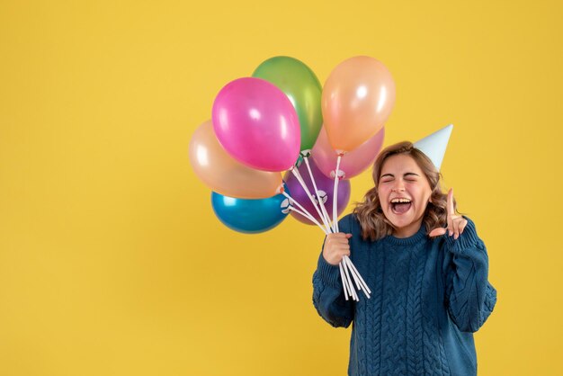 Vorderansicht junge Frau mit bunten Luftballons