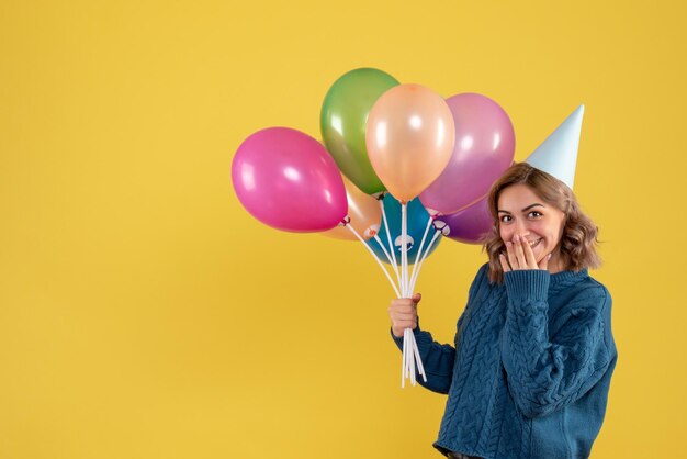 Vorderansicht junge Frau mit bunten Luftballons