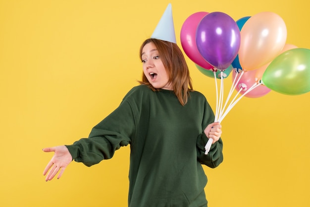 Vorderansicht junge Frau mit bunten Luftballons