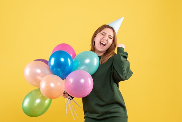 Vorderansicht junge Frau mit bunten Luftballons