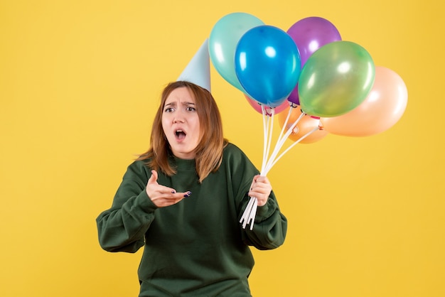 Vorderansicht junge Frau mit bunten Luftballons