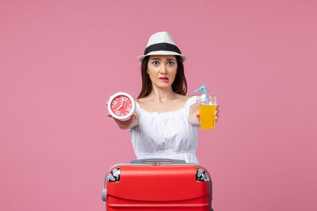 Vorderansicht junge Frau mit Cocktail und Uhr im Urlaub auf rosa Wand Urlaub Hitze Reise Reise Sommer