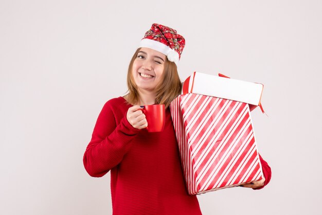 Vorderansicht junge Frau mit Geschenk und Tasse Tee