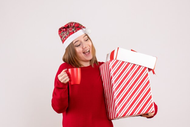 Vorderansicht junge Frau mit Geschenk und Tasse Tee