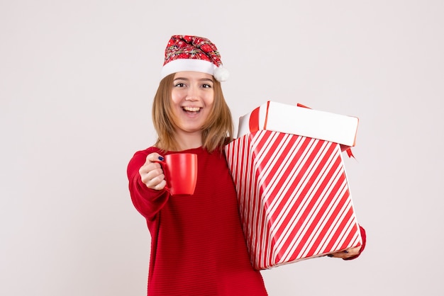 Vorderansicht junge Frau mit Geschenk und Tasse Tee