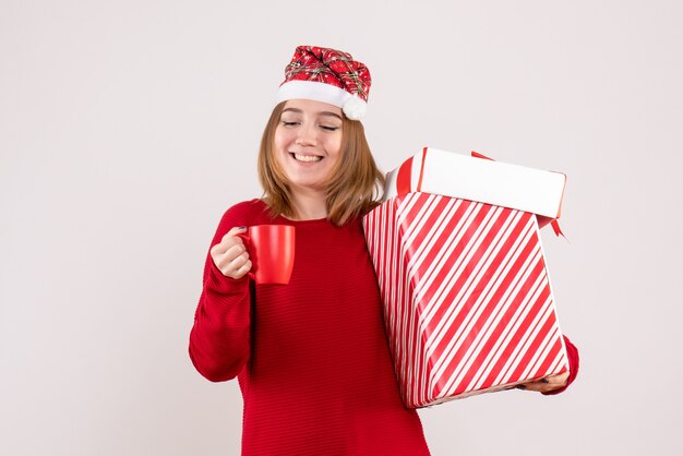 Vorderansicht junge Frau mit Geschenk und Tasse Tee