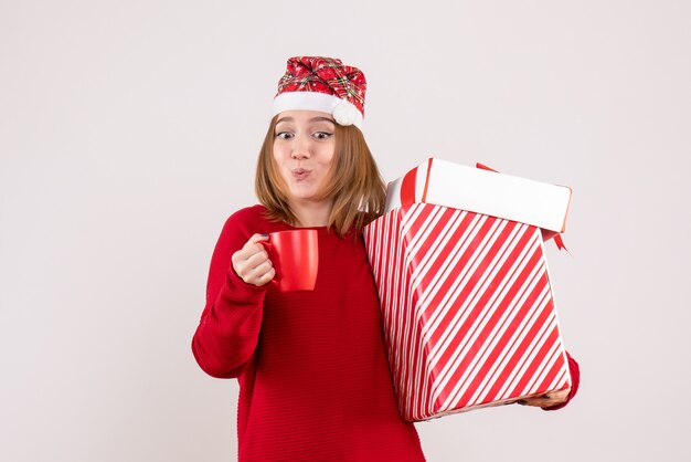 Vorderansicht junge Frau mit Geschenk und Tasse Tee