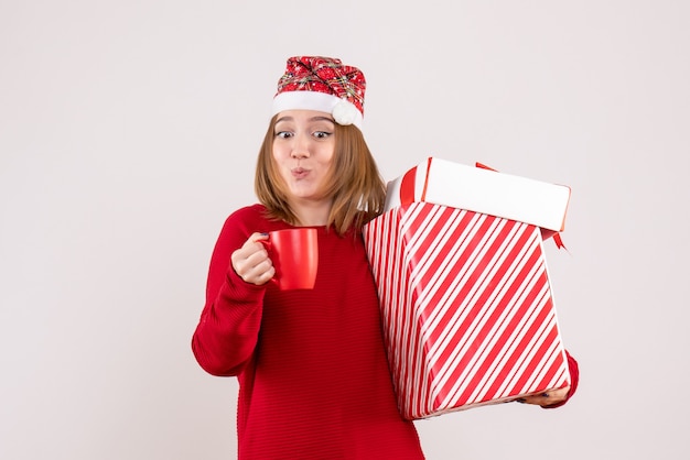 Vorderansicht junge Frau mit Geschenk und Tasse Tee