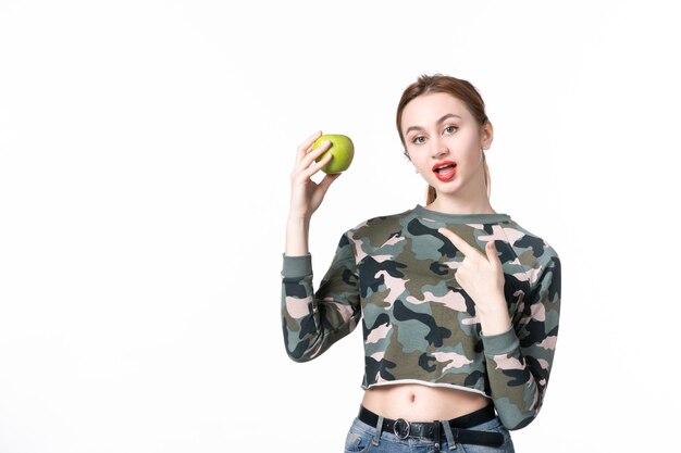 Vorderansicht junge frau mit grünem apfel auf weißem hintergrund mahlzeit menschlicher fruchtsaft farben diät gericht essen baum