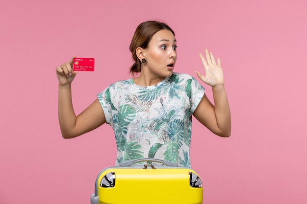 Vorderansicht junge Frau mit roter Bankkarte auf rosa Wand Flug Frau Reise Flugzeug Urlaub Rest