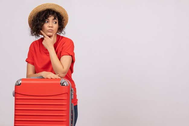 Vorderansicht junge Frau mit roter Tasche, die sich auf eine Reise auf einem weißen Hintergrund vorbereitet