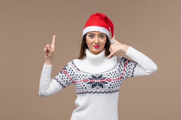 Vorderansicht junge Frau mit roter Weihnachtsmütze auf braunem Schreibtischweihnachtsgefühl Neujahr