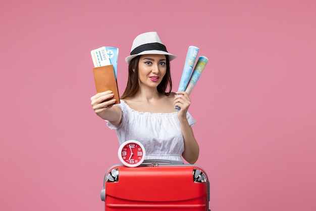Vorderansicht junge Frau mit Tickets und Karte im Urlaub auf der rosa Wand Hitze Urlaubsreise Sommerfrau Reise