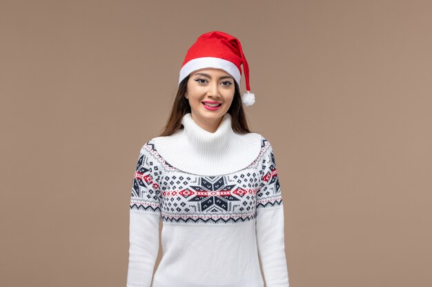 Vorderansicht junge Frau mit Weihnachtsumhang auf dem braunen Hintergrundfeiertagsemotionsweihnachten